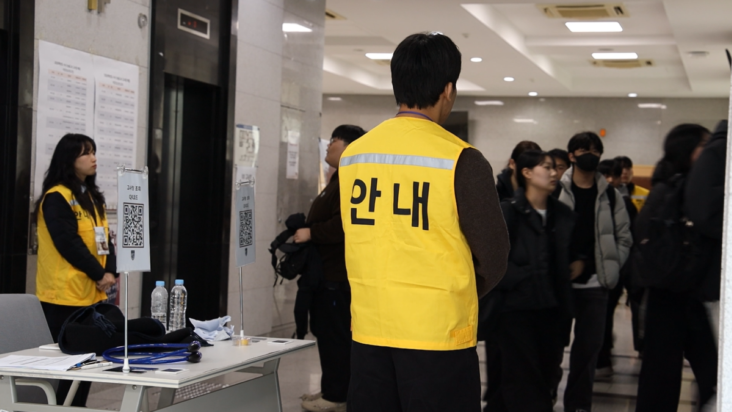 수험실로 들어가는 학생들을 안내하는 직원들 