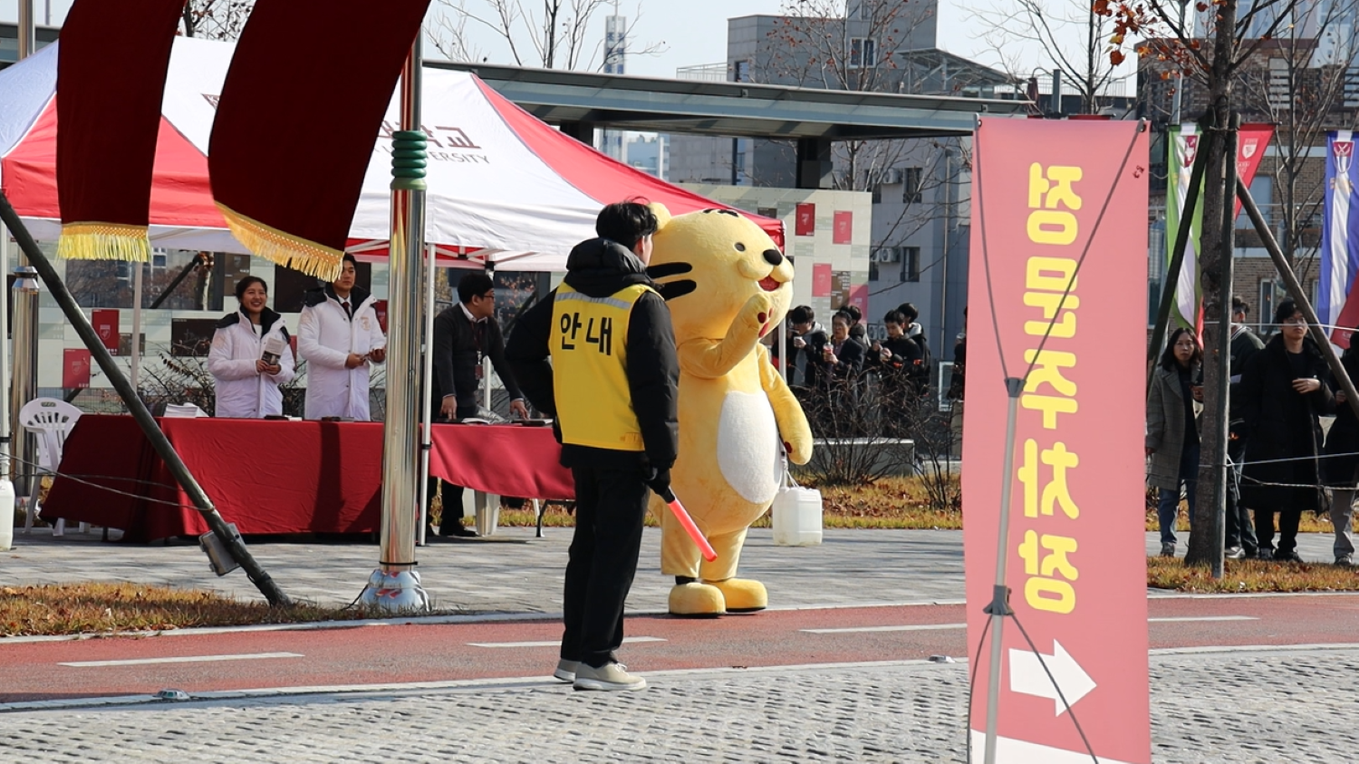 정문에서 주차를 관리하는 직원들과 인사하는 호이 